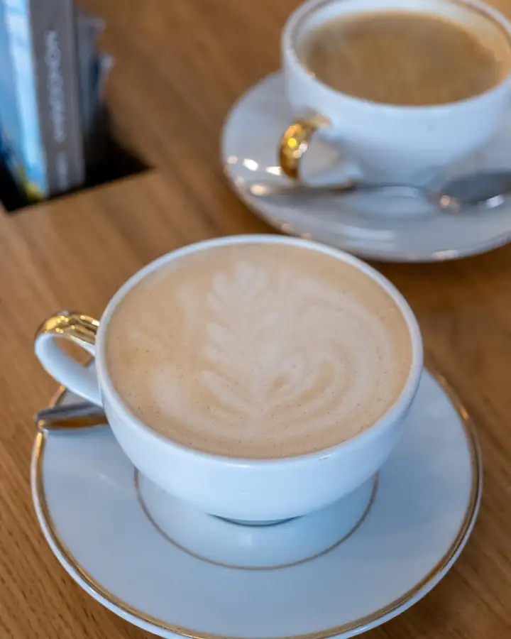 Latte in a blue cup on a wooden table