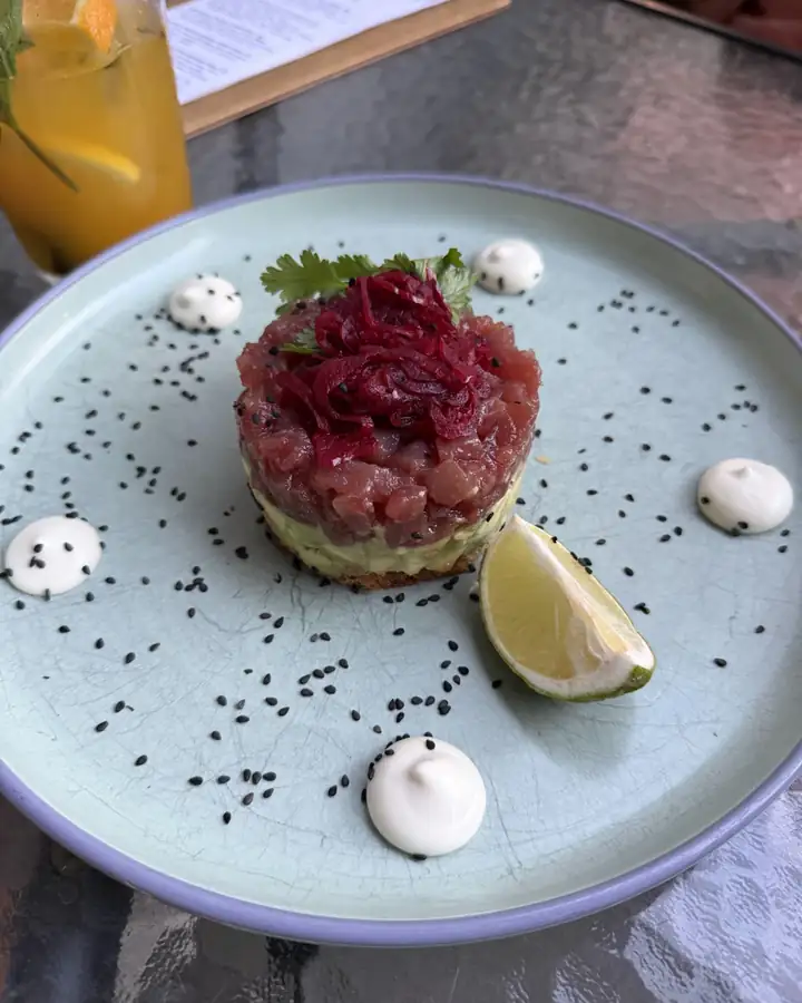 Beetroot and beef tartare on a grey plate with black sesame